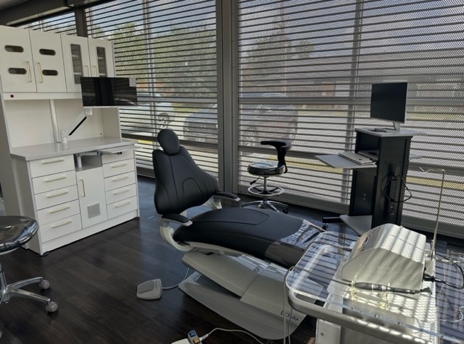 A dental office with a chair and desk

Description automatically generated