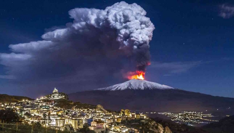A volcano erupting in the night sky

Description automatically generated