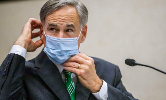 FILE - In this June 16, 2020, file photo, Texas Gov. Greg Abbott adjusts his mask after speaking in Austin, Texas.  Abbott on Thursday, July 2, ordered that face coverings must be worn in public across most of the state, a dramatic ramp up of the Republican's efforts to control spiking numbers of confirmed coronavirus cases and hospitalizations. (Ricardo B. Brazziell/Austin American-Statesman via AP, File)