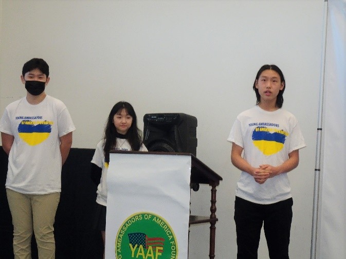 A group of people standing next to a podium

Description automatically generated with low confidence