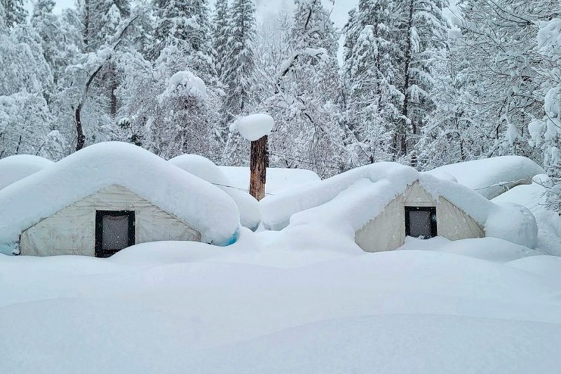 In this photo provided by the National Park Service, tents at Curry Village are covered with snow in Yosemite National Park, Calif., Tuesday, Feb. 28, 2023. The park, closed since Saturday because of heavy, blinding snow, postponed its planned Thursday, March 2, 2023, reopening indefinitely. (National Park Service via AP) ORG XMIT: FX308